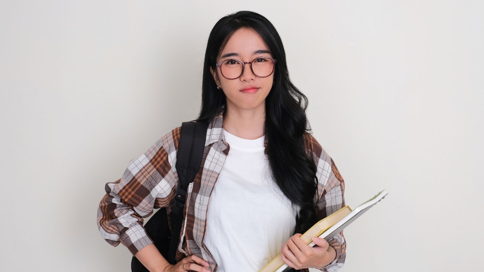 Employee Gets Unexpected Chance to Get Even With Condescending Former Supervisor in College Class female college student holding books and wearing glasses