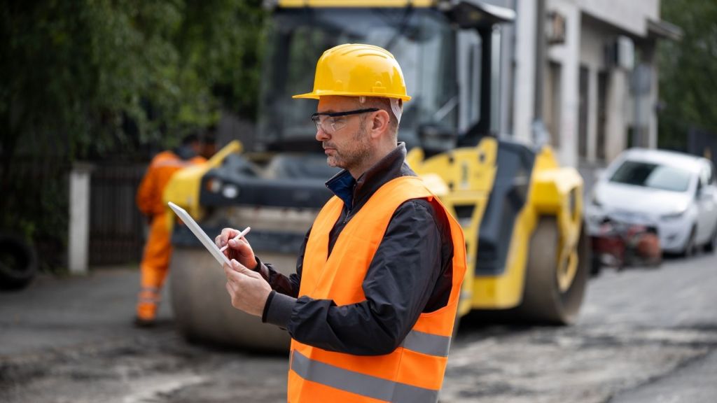 road construction worker writing something on a clipboard