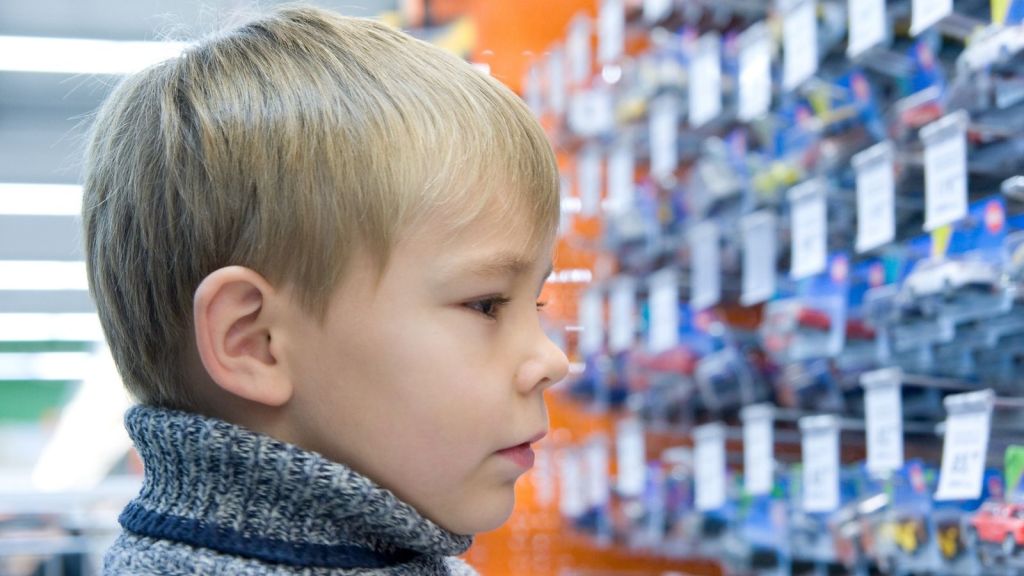 boy looking at toy cars at a store