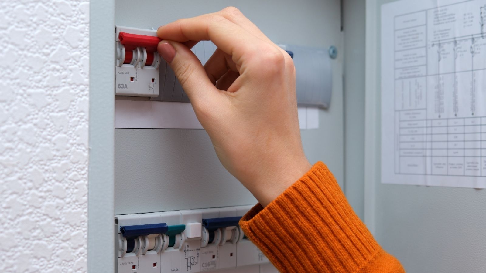 A Woman Says Her Neighbor Accuses Her Of “Messing With Her” Over Repeated Power Outages, Leaving Her Feeling Threatened woman's hand flipping circuit breaker