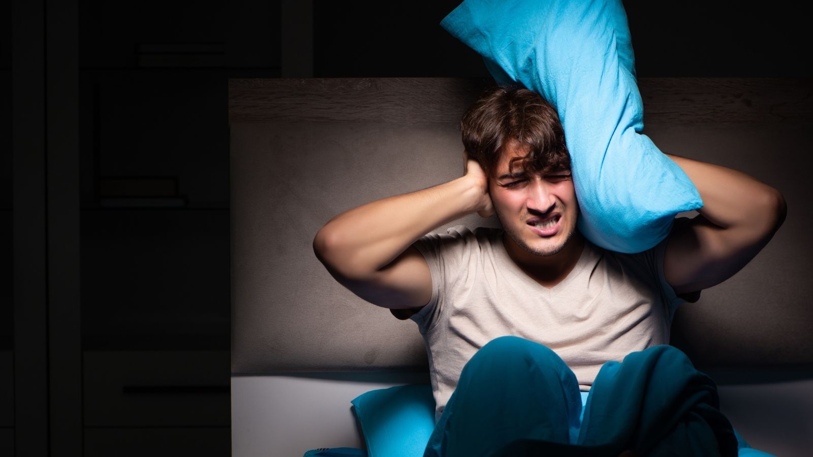 man unable to sleep because of noise