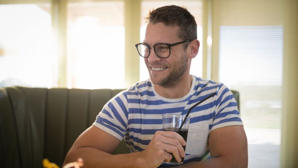 happy man drinking soda in a restaurant