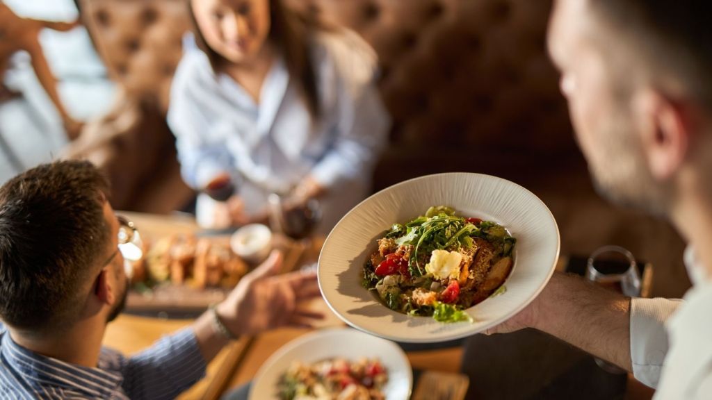 waiter bringing food to a table