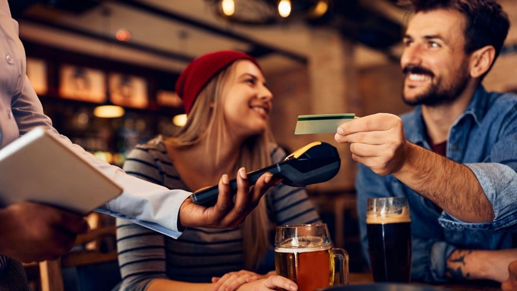 man paying waitress with credit card