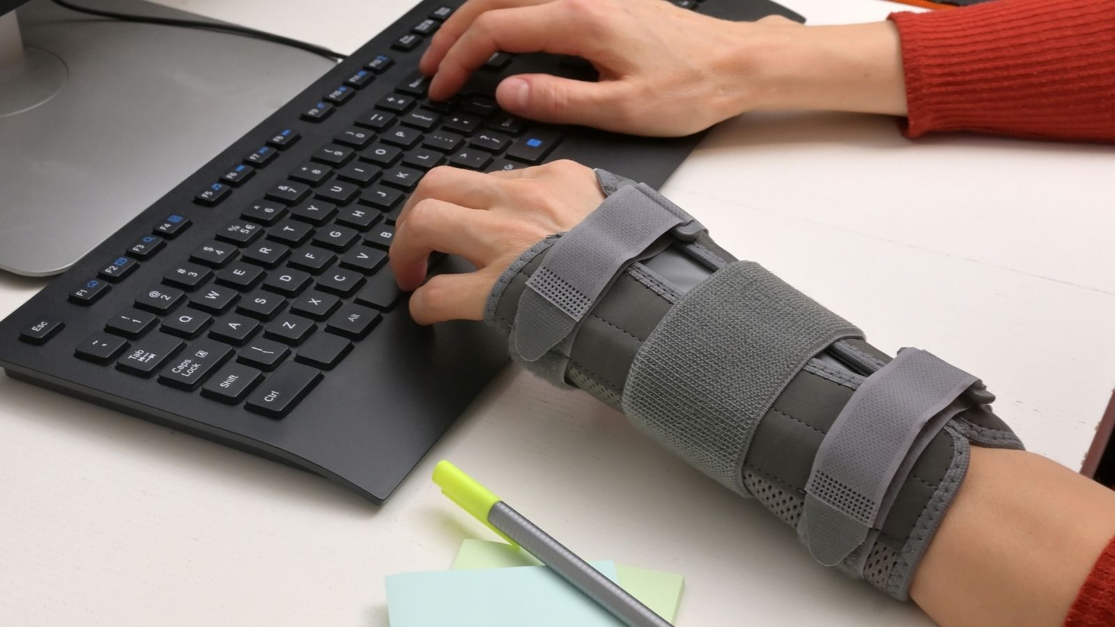 woman typing while wearing a wrist brace