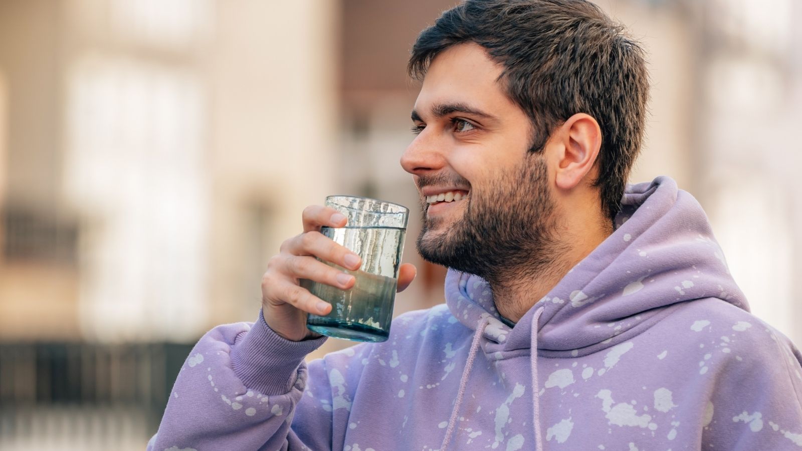 man holding a drinking glass outside