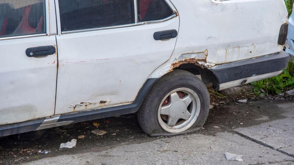 old white car with flat tire