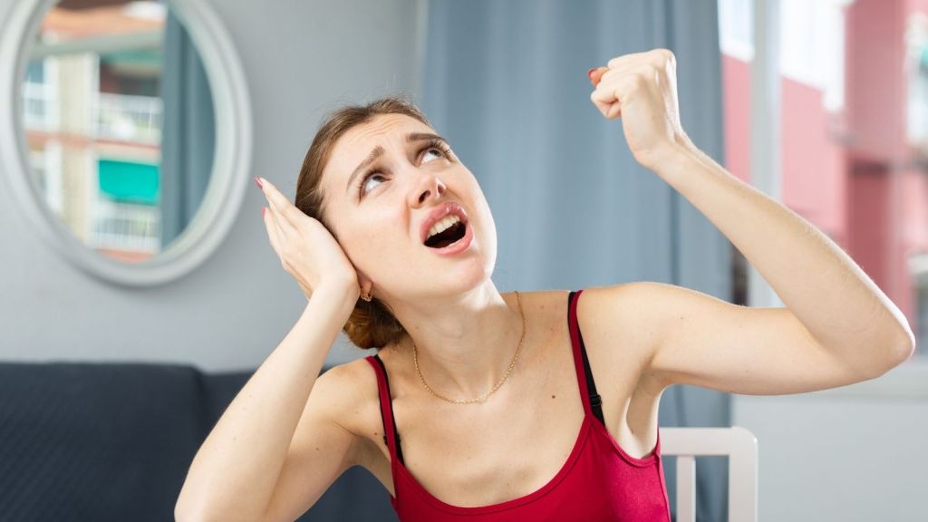 young woman upset at noisy upstairs neighbor