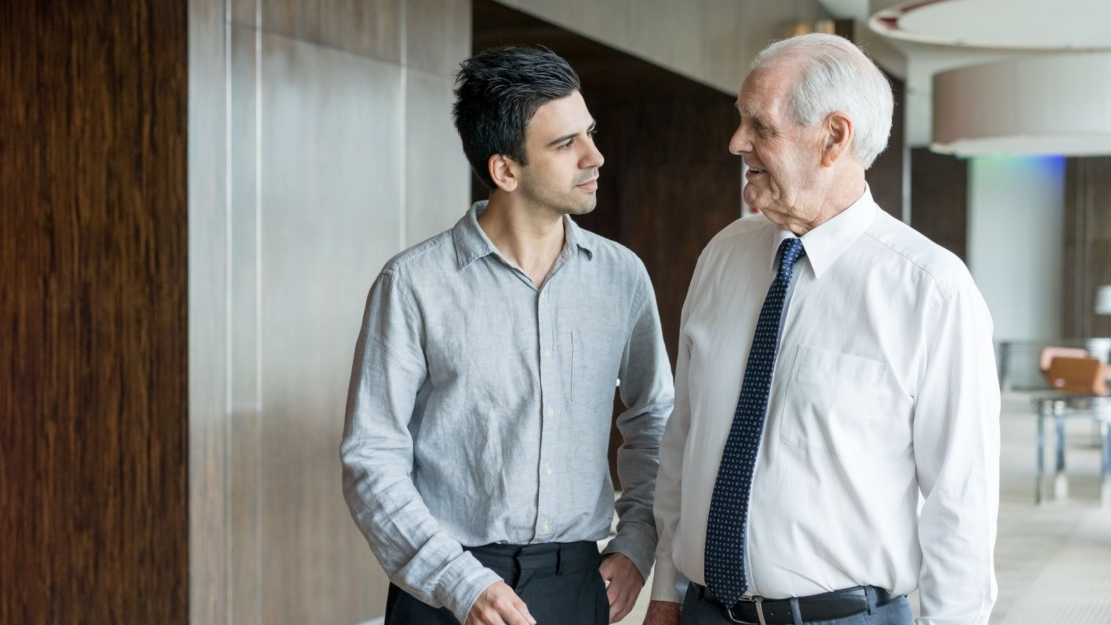 young man talking to senior employee