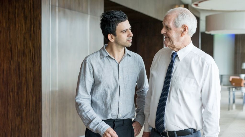 young man talking to senior employee
