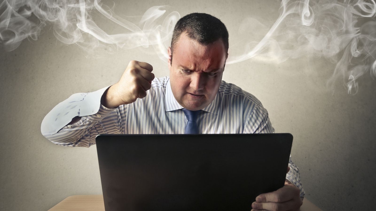 furious businessman looking at laptop computer