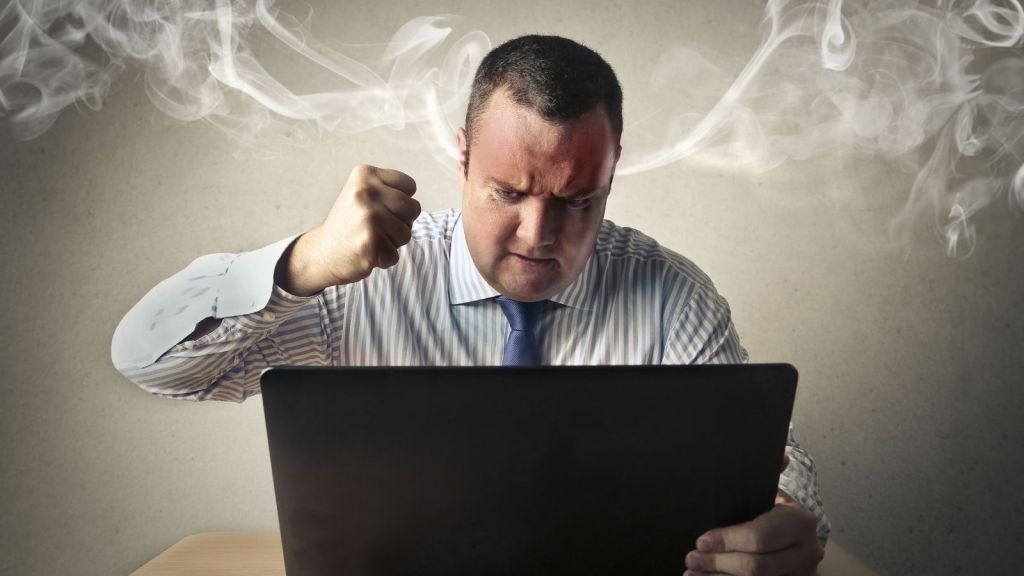 furious businessman looking at laptop computer