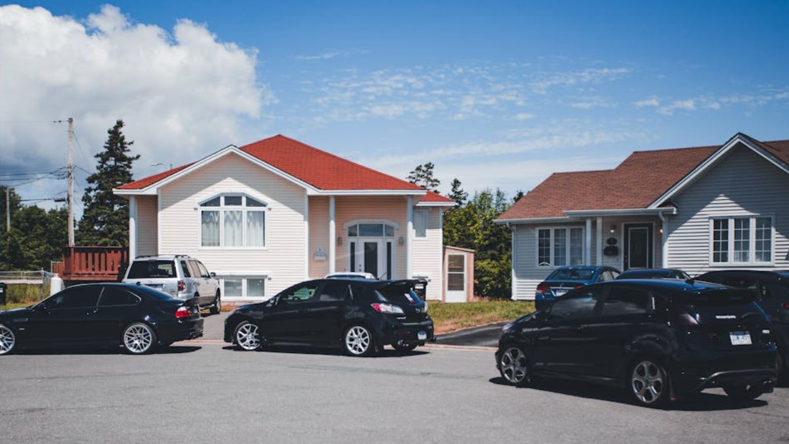 A clean and quiet neighborhood with cars parked on the side of the road