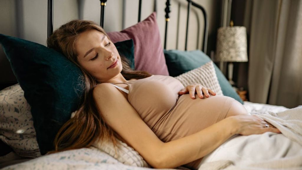 Pregnant woman relaxing on her bed