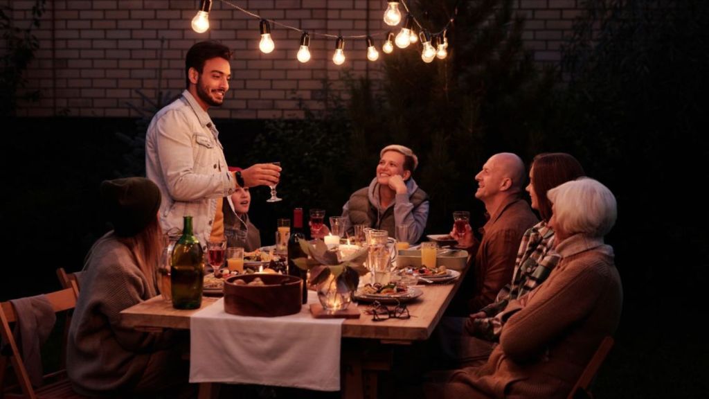 Adults having dinner outdoors at night