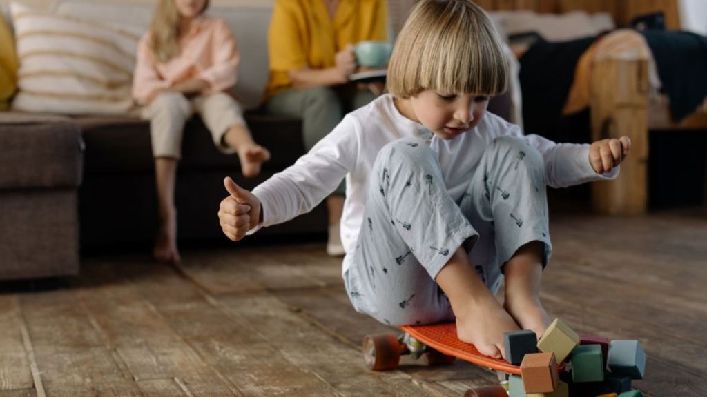 Boy playing with skateboard on the floor with other people at the back