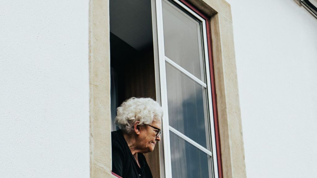 Elderly woman looking out her window