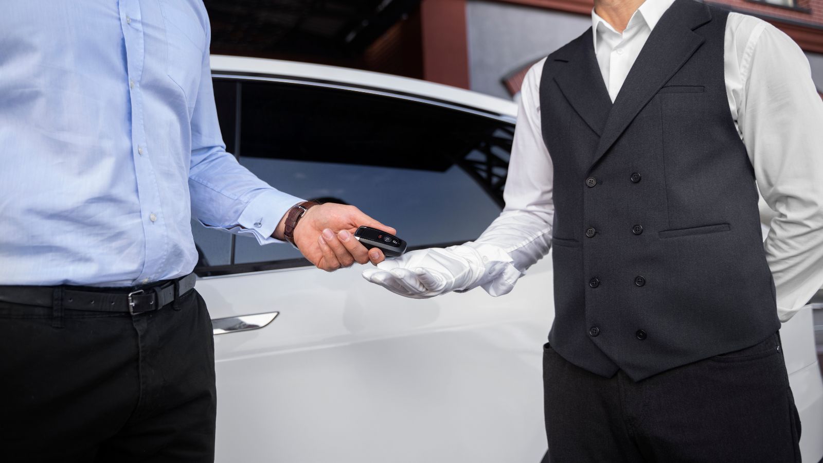 Hotel Valet Worker Exposes the Daily Chaos of Tracking Million Dollar Cars With Paper Tickets Man handing his ar key to the valet attendant