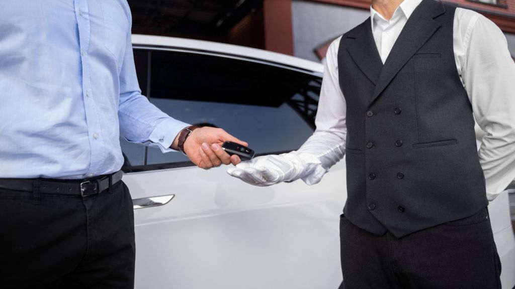 Man handing his ar key to the valet attendant