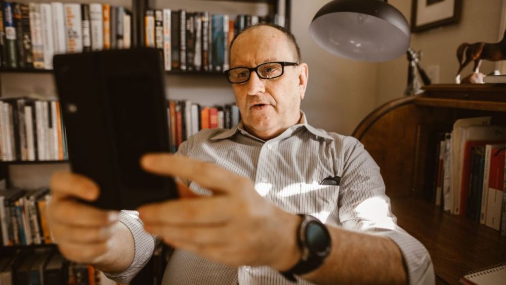 Middle aged man using his phone to capture video