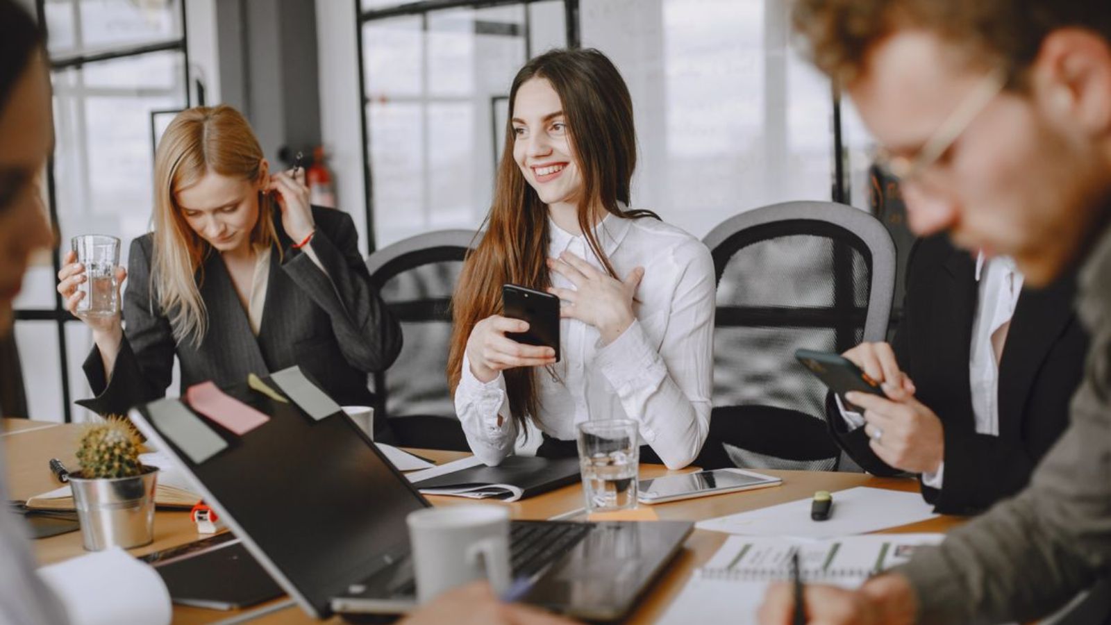 Employee Repeatedly Corrects Coworker on Name Pronunciation, but “Grey Ham” Nickname Causes Workplace Tension Woman smiling during an office meeting