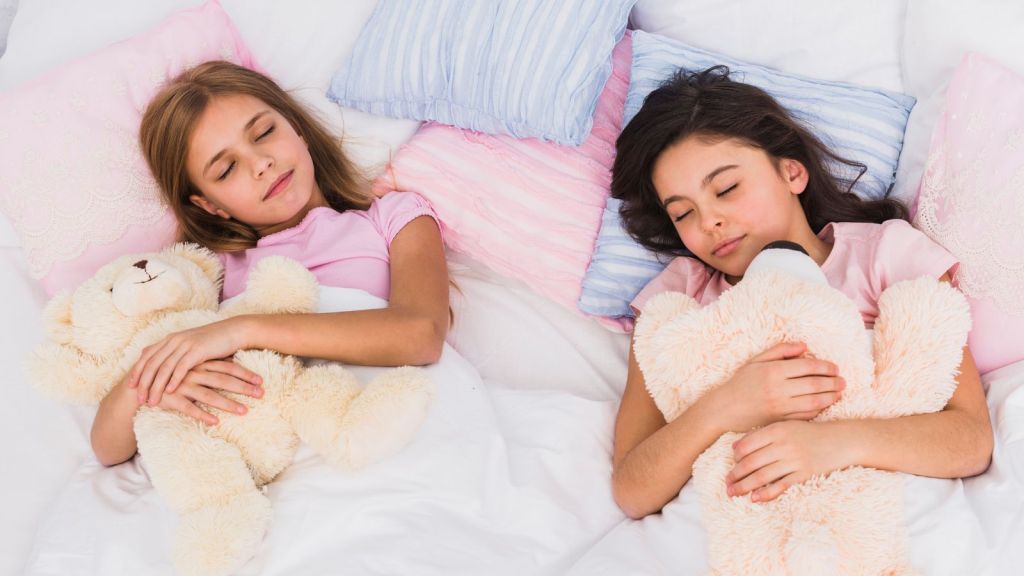 Two young girls sharing a bed to sleep in
