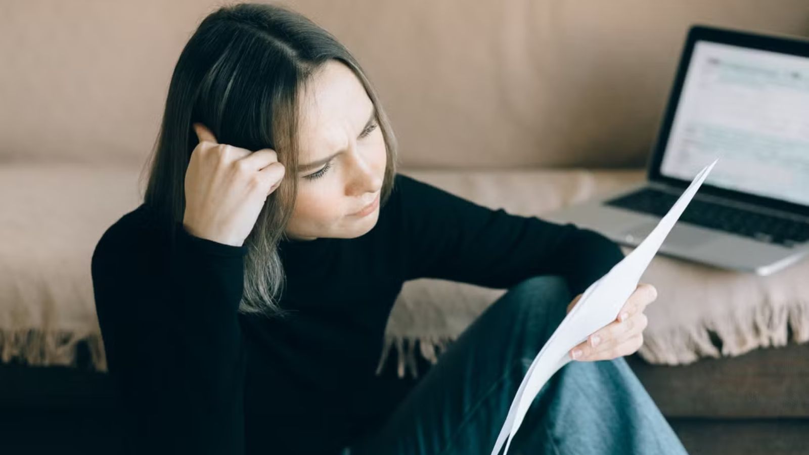 Flatmate Refuses to Pay Her Share of the Bills Because She ‘Wasn’t Even There’ SWoman looking at her bills and feeling stressed