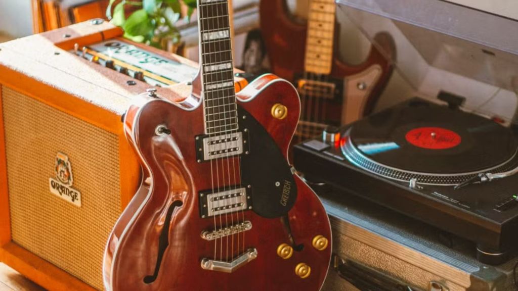 a vintage guitar, vinyl turntable, and amplifier setup for music enthusiasts