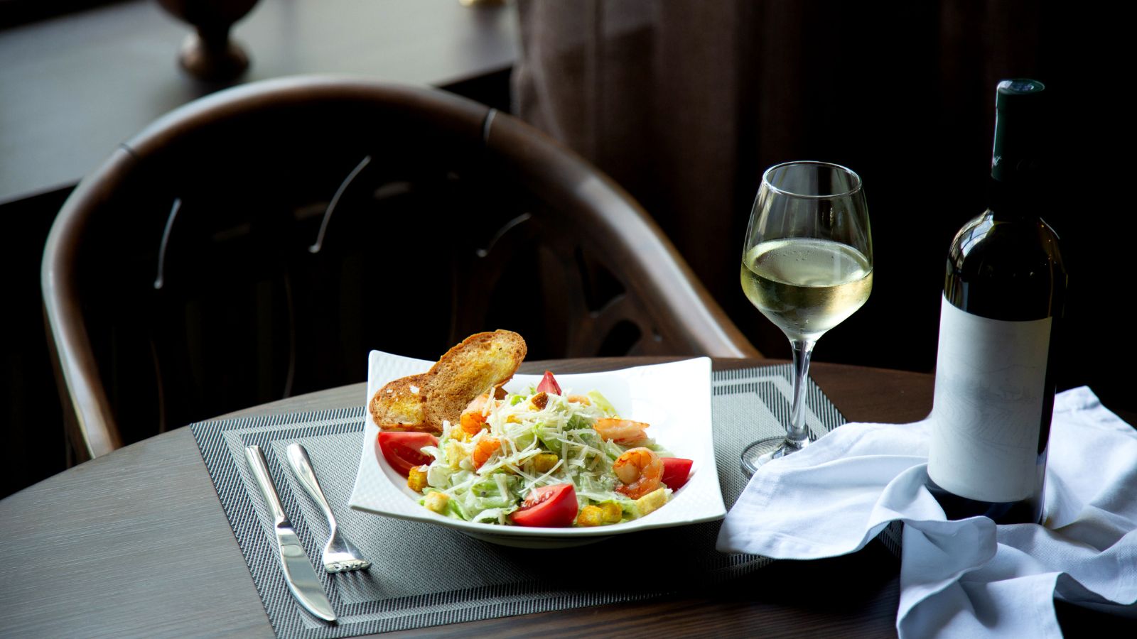 Bartender Shocked After Big Spending Guest Leaves Massive Cash Tip on Expensive Wine Order A bowl of salad and glass of white wine perfectly set on the table
