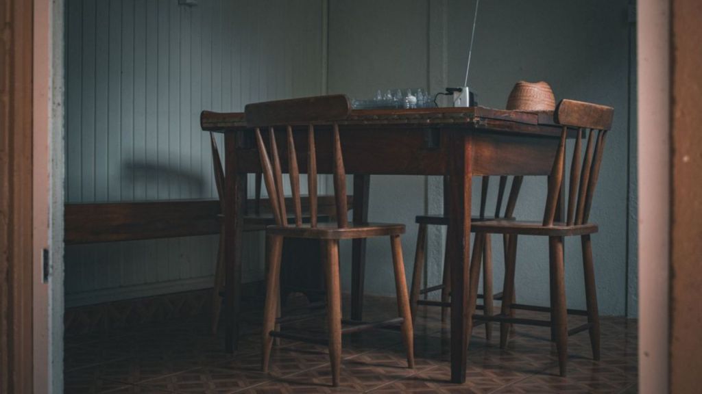Cozy indoor scene featuring a wooden table and chairs, with a vintage radio