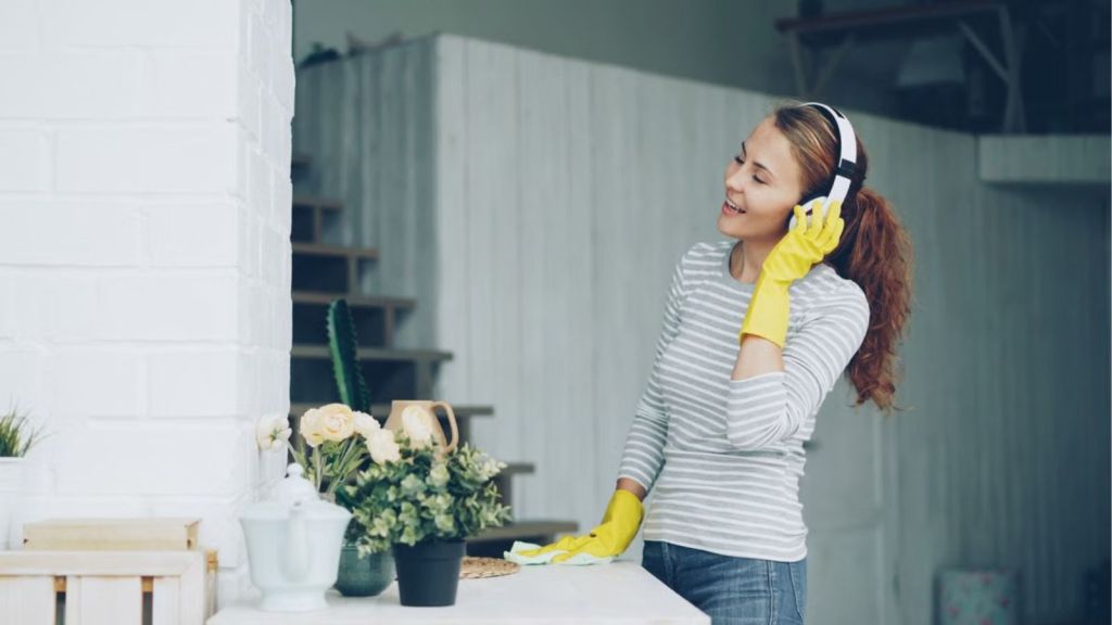 Woman with headphones singing while cleaning