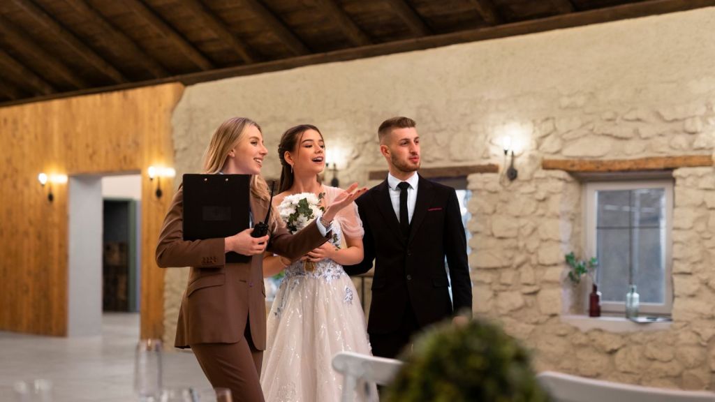 Wedding coordinator giving instructions to bride and groom on their wedding