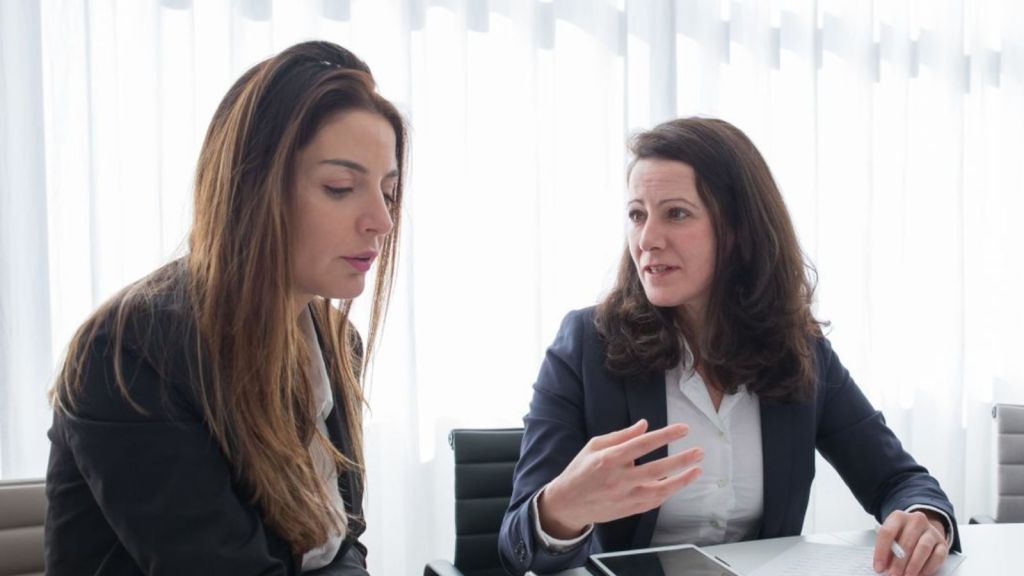 Two female employees talking to each other about a serious matter