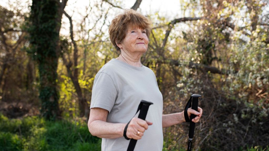 Elderly woman wlaking outdoors with walking sticks