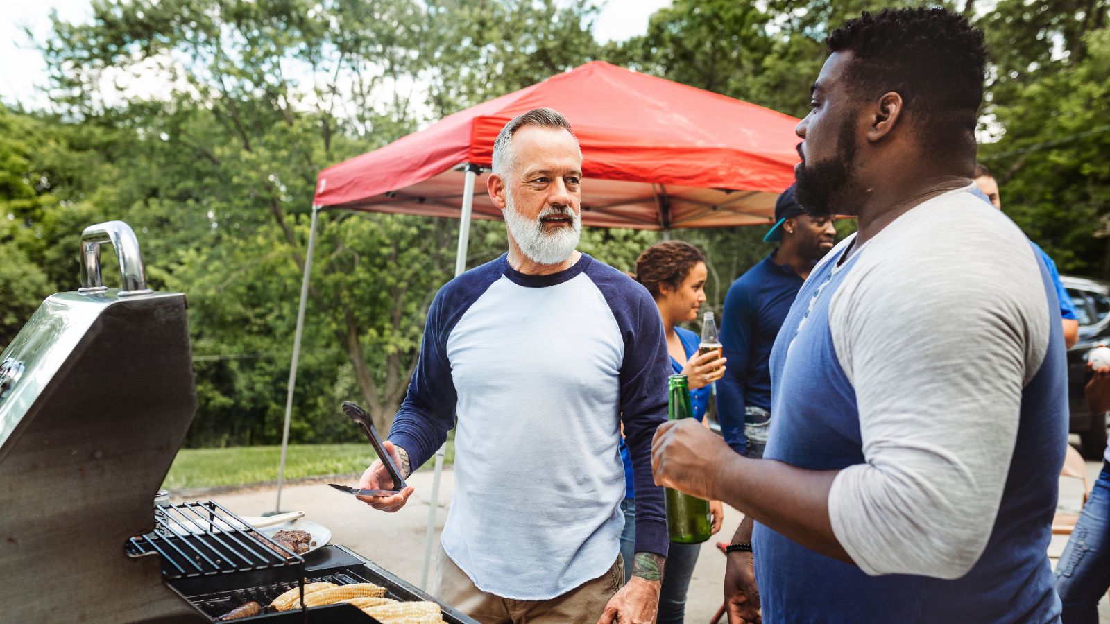 Adults having barbecue in their backyard