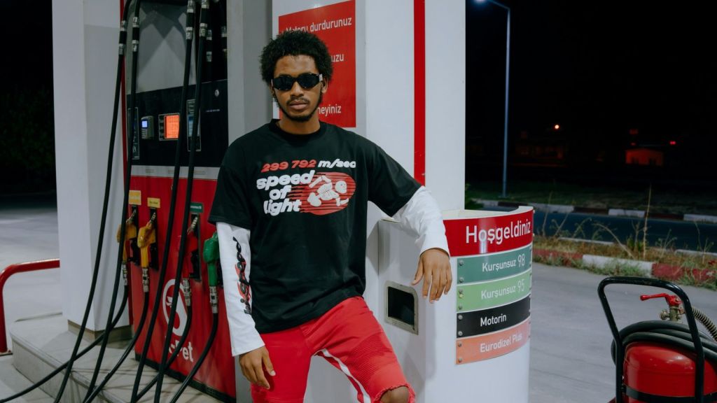 Man wearing sunglasses standing next to a gas pump