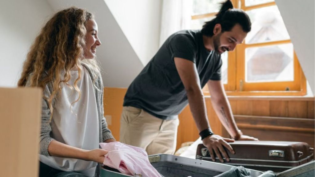 Man and woman packing their personal things in 2 pieces of luggage