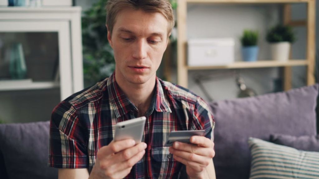 Man using his credit card to pay for an online purchase on his phone