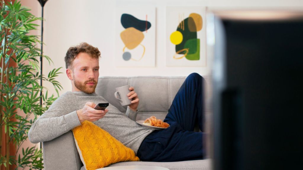 Man watching TV with sitting comfortably on the couch