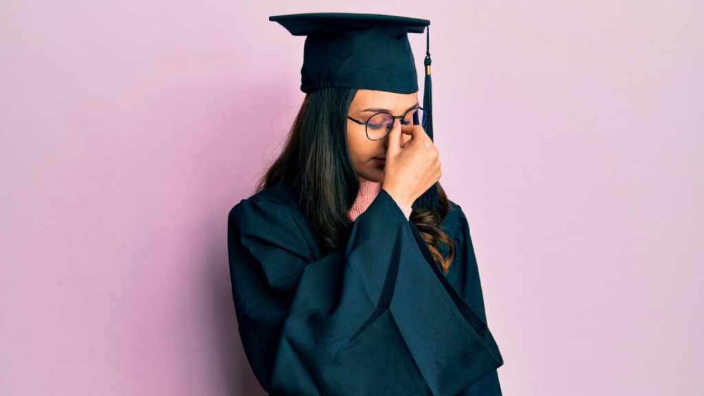 Woman wearing graduation outfit and glasses