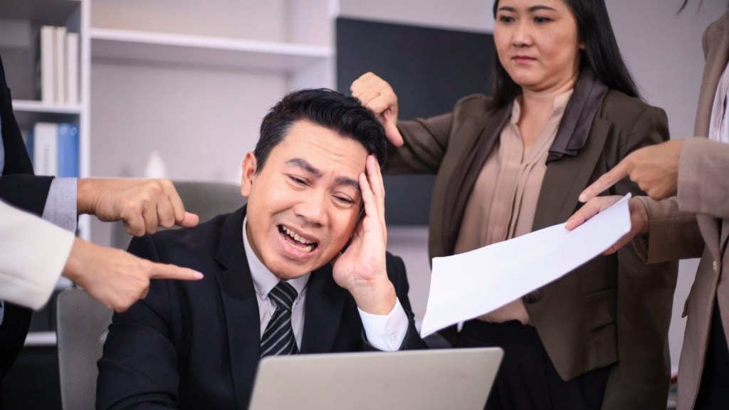 Businessman looks stressed near colleagues