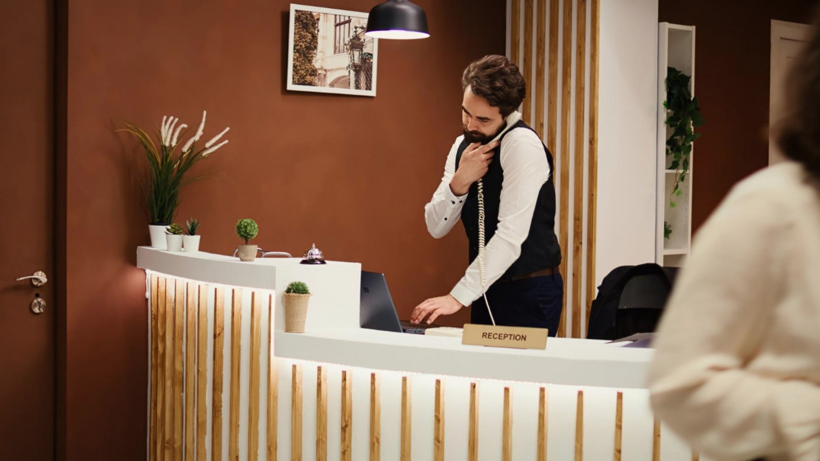 Hotel staff making a call at reception