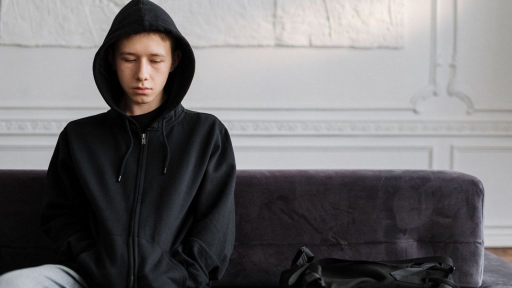 Boy in black hoodie upset