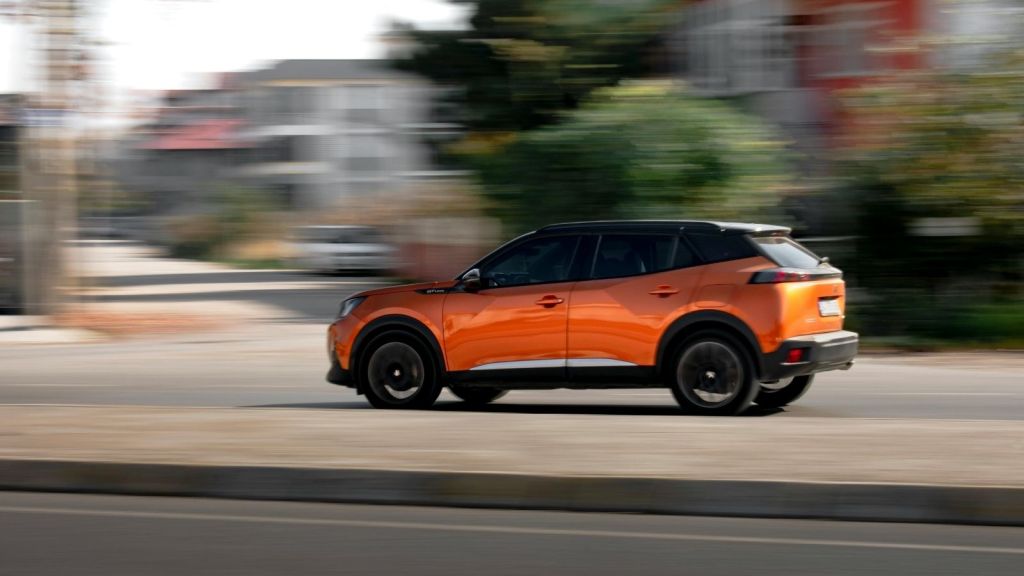 An orange car driving on a road