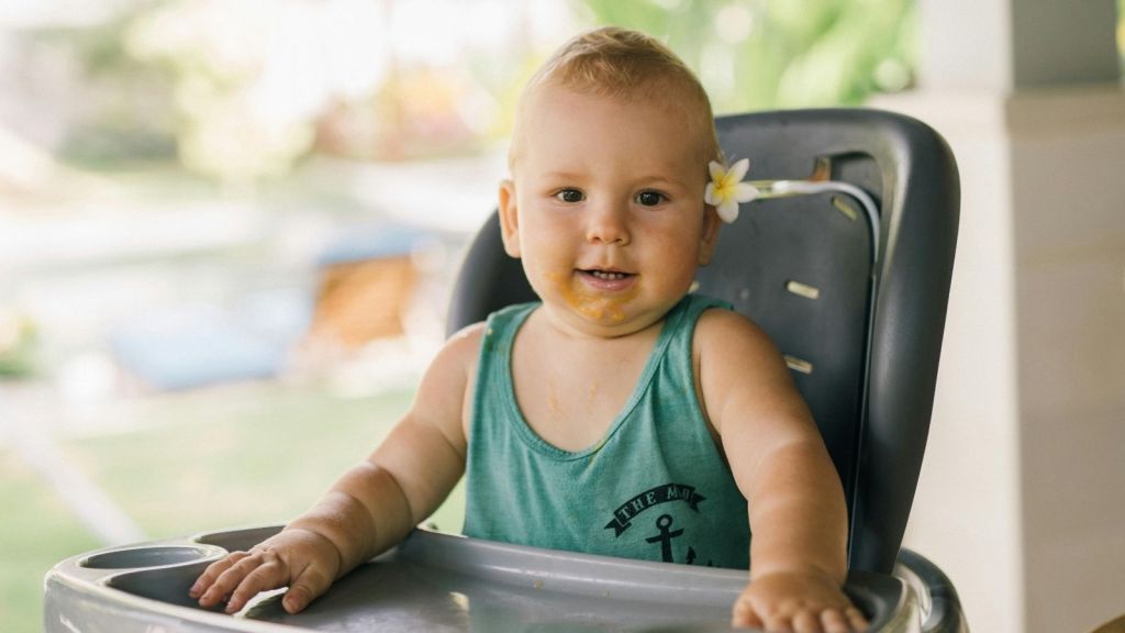 Baby smiling in high chair