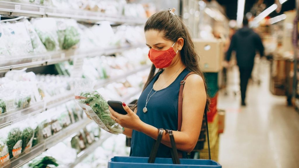 Woman looked at container of lettuce in supermarket