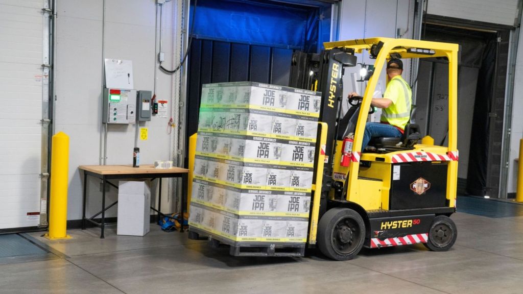 A machine moves a pallet of stacked inventory