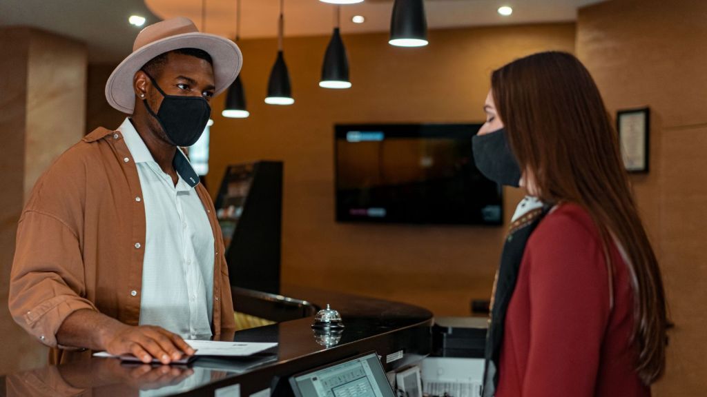 Man in mask at hotel reception