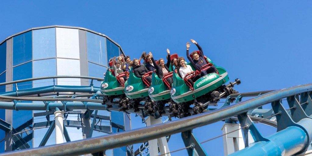people riding a roller coaster at an amusement park