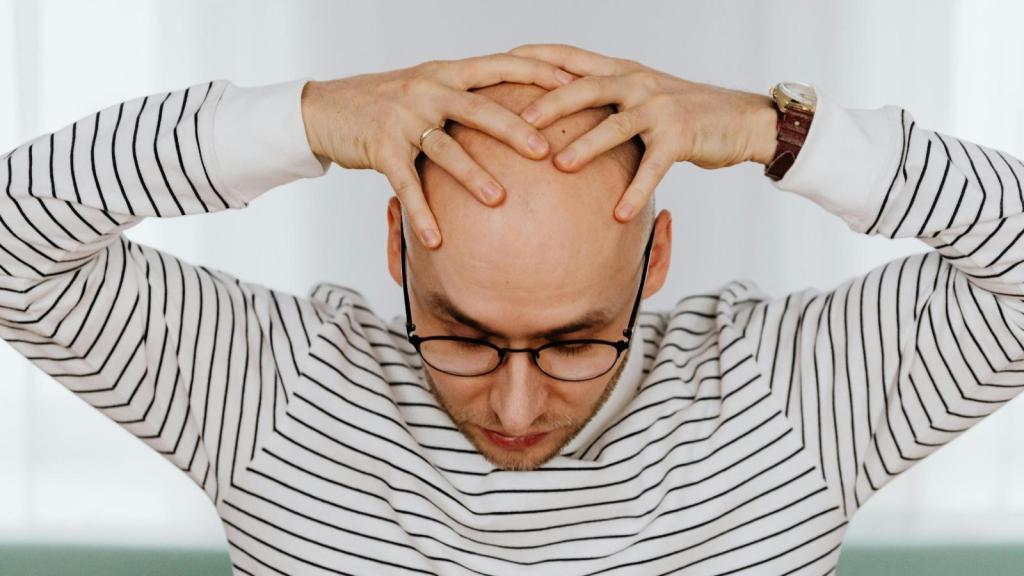 bald man touching bald head